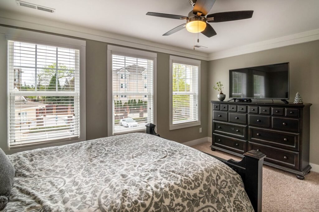 Spacious bedroom featuring elegant decor, modern furniture, and abundant natural light.